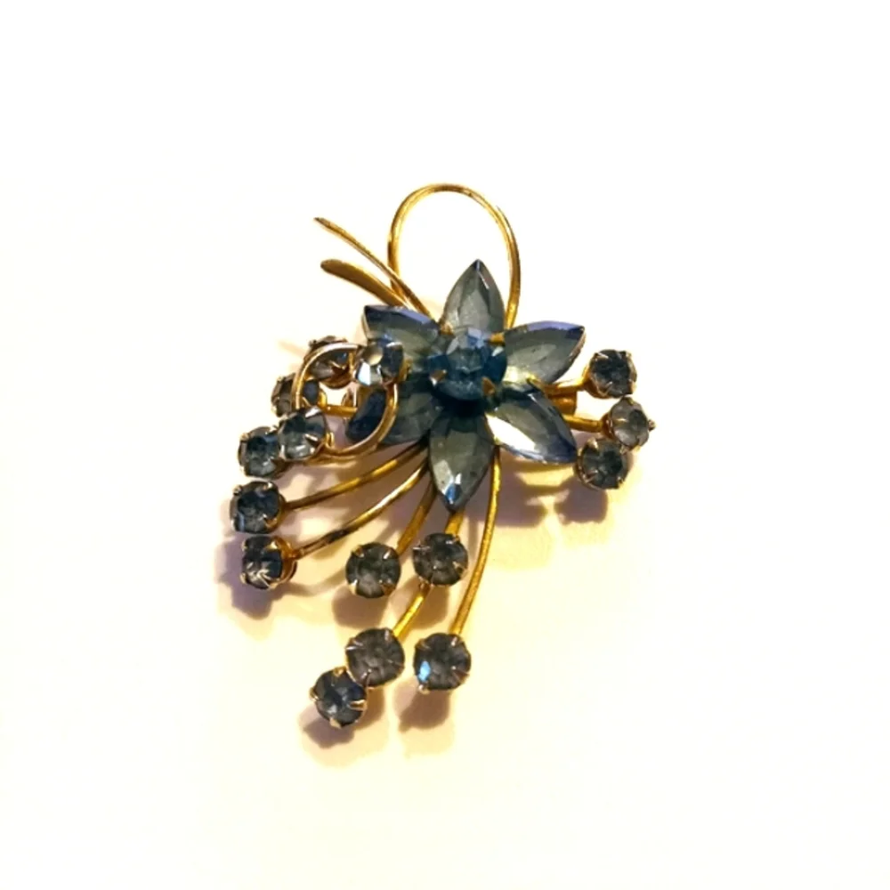 Vintage goldtone blue rhinestone flower brooch.
